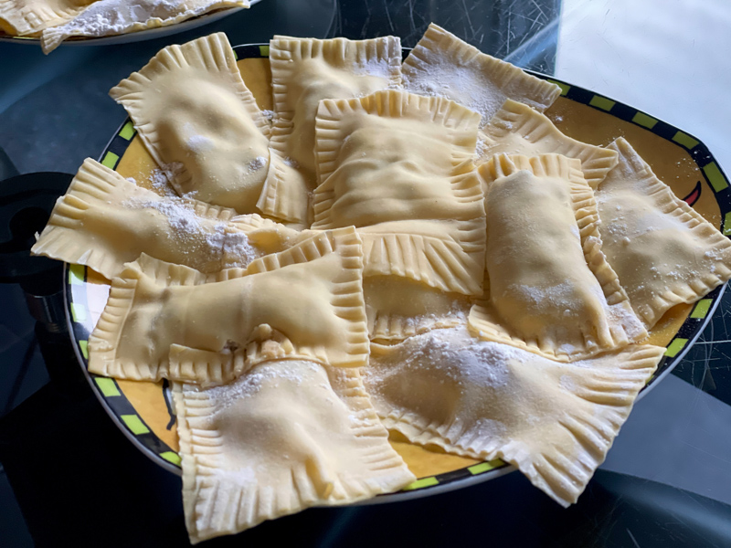 Zubereitungsschritt für „Südtiroler Schlutzkrapfen á la Martina“. Ungekochte Teigtaschen auf einem Teller mit Mehl bestäubt.