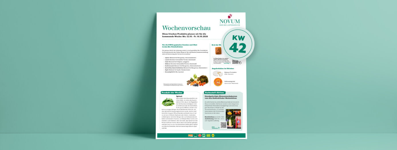 Vorschau eines Informationsblatts von NOVUM – Der Bio-Lieferservice – mit dem Titel „Wochenvorschau“. Es zeigt Inhalte für die Bio-FrischeKisten der Folgewoche – Kalenderwoche 42/2026 – zudem Rezeptvorschläge und allgemeine Produktinfos. Im Mittelteil aufgelistet sind regionale Obst- und Gemüsesorten, das Brot der Woche und das Käse-Monatsangebot. Darunter steht links ein Infotext über Spinat, der in KW42 in der Kiste sein wird. Darunter ist die Abbildung von frischen Spinatblättern zu sehen. Rechts daneben steht ein zweiter Informationsblock mit dem Hinweis auf handgefertigete Bienenwachskerzen von den Hohenfrieder Werkstätten, die ab sofort im Onlineshop erhältich sind. Das Design ist schlicht, mit grüner Akzentfarbe auf weißem Hintergrund, dargestellt auf einem hellgrünen Wandhintergrund.